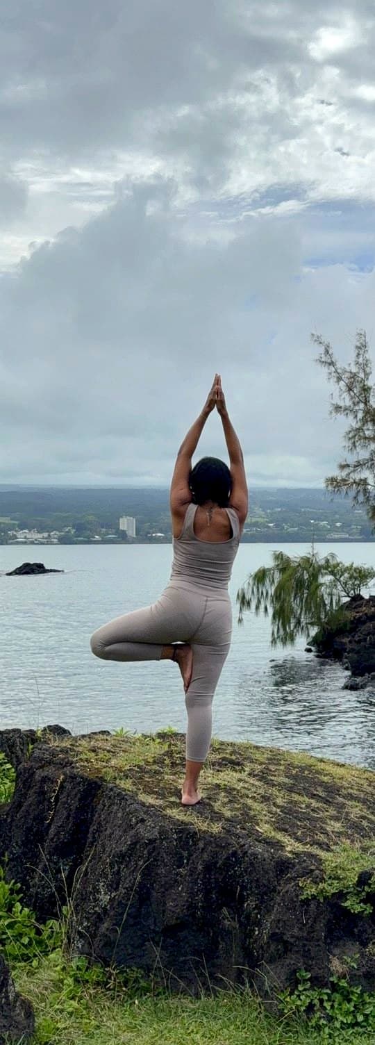 Tree pose on a rock overlooking the bay.